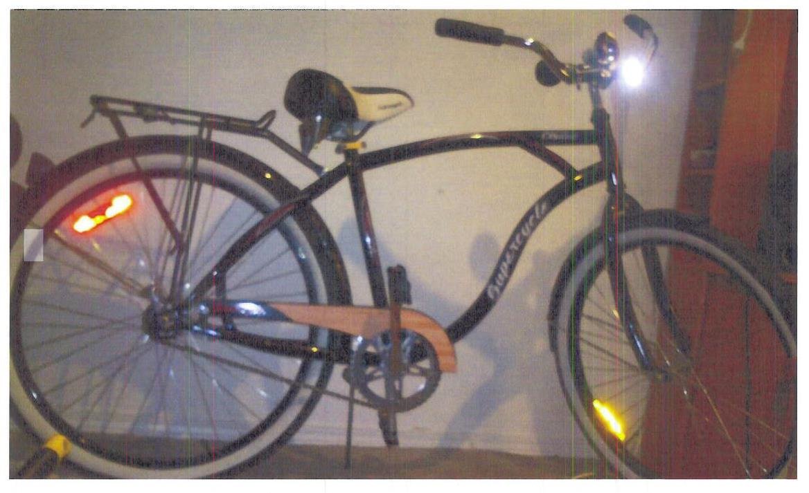 Image of Kandice's bike that she was last seen riding. A dark-coloured men’s “Supercycle Cruiser Classic” with whitewall tires and a faux wood-grain chain guard.