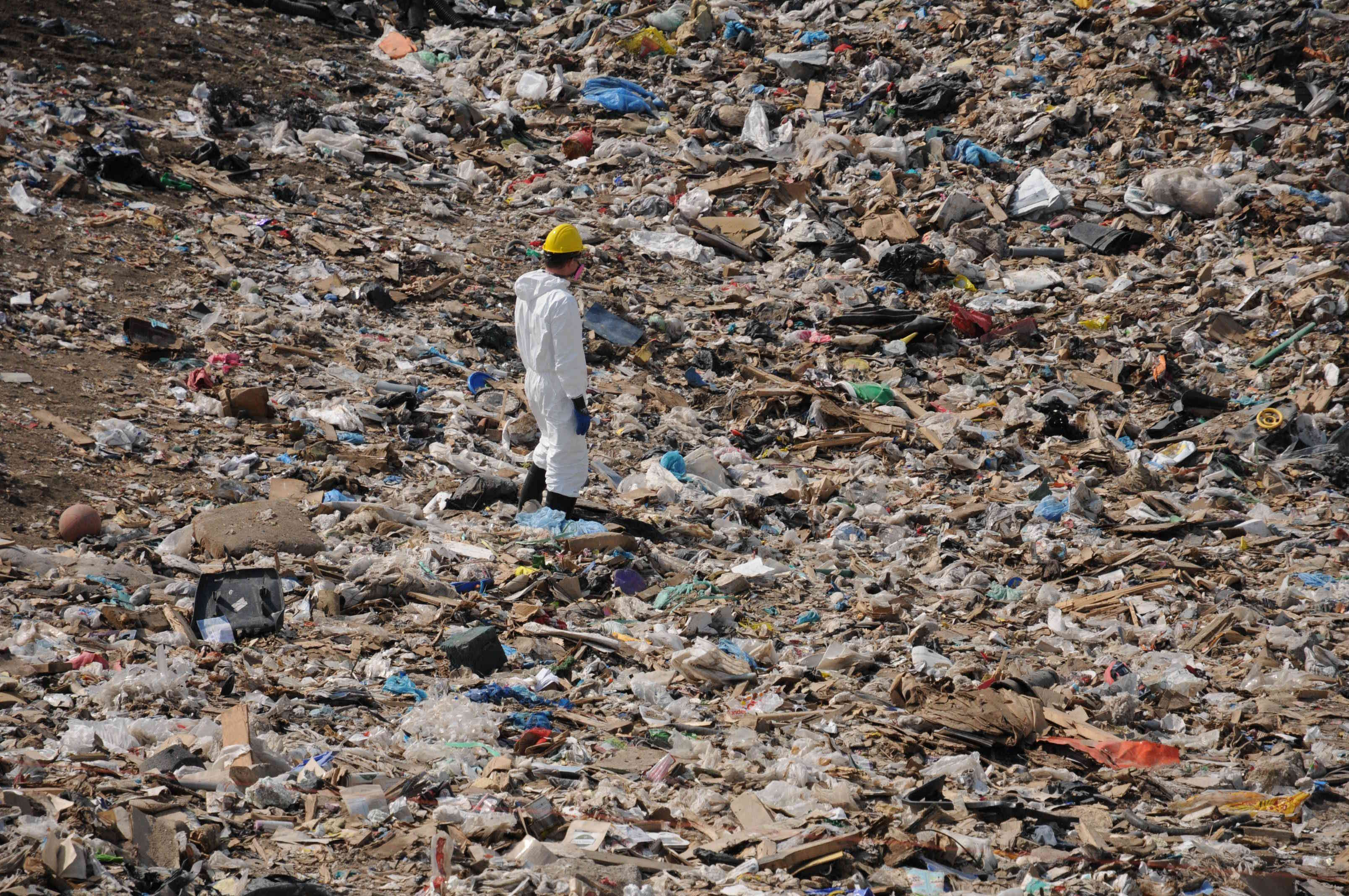 A search member in personal protective equipment stands amongst the garbage that was being searched for Kandice Singbeil.